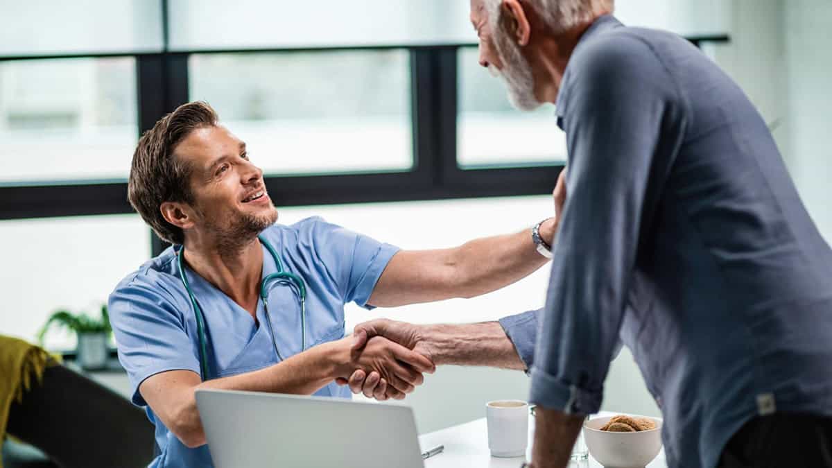Elderly patient shaking hand with his healthcare provider.