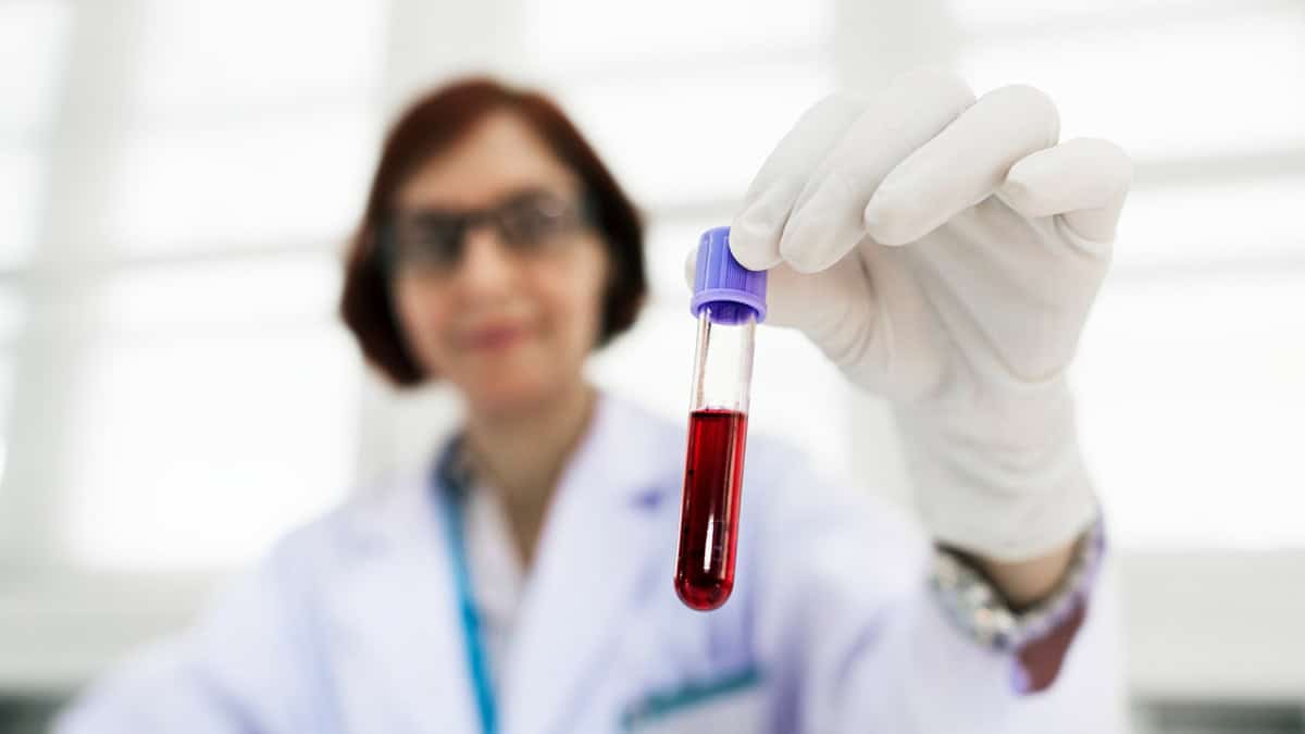 Lab technician holding a blood sample in a tube