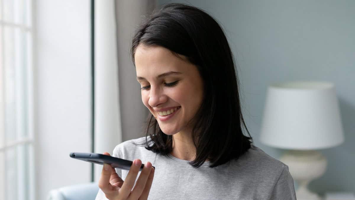 A person talking on a cell phone using the speaker function