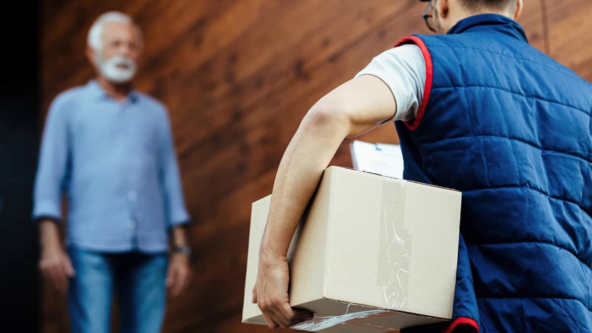 Person receiving a mail package at his door step