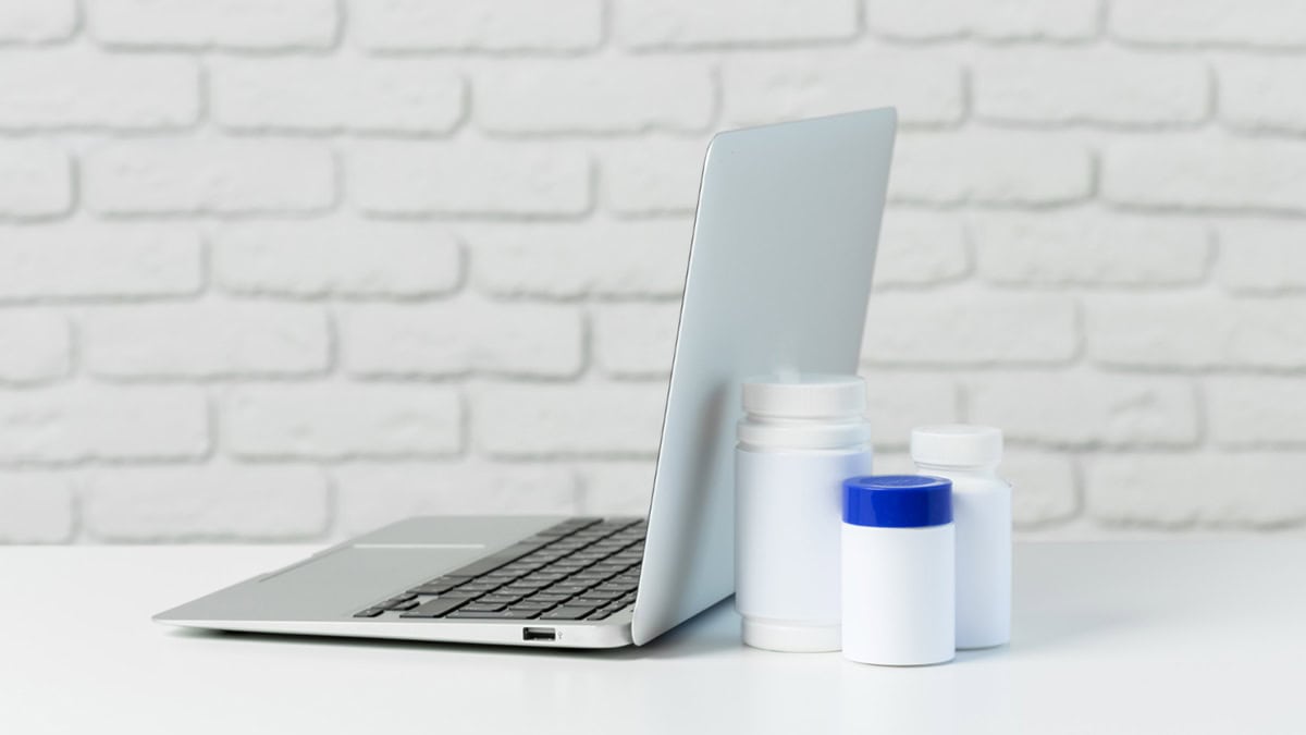 Medication bottles behind laptop