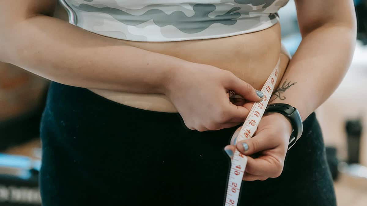 Women measuring her waist with measuring tape